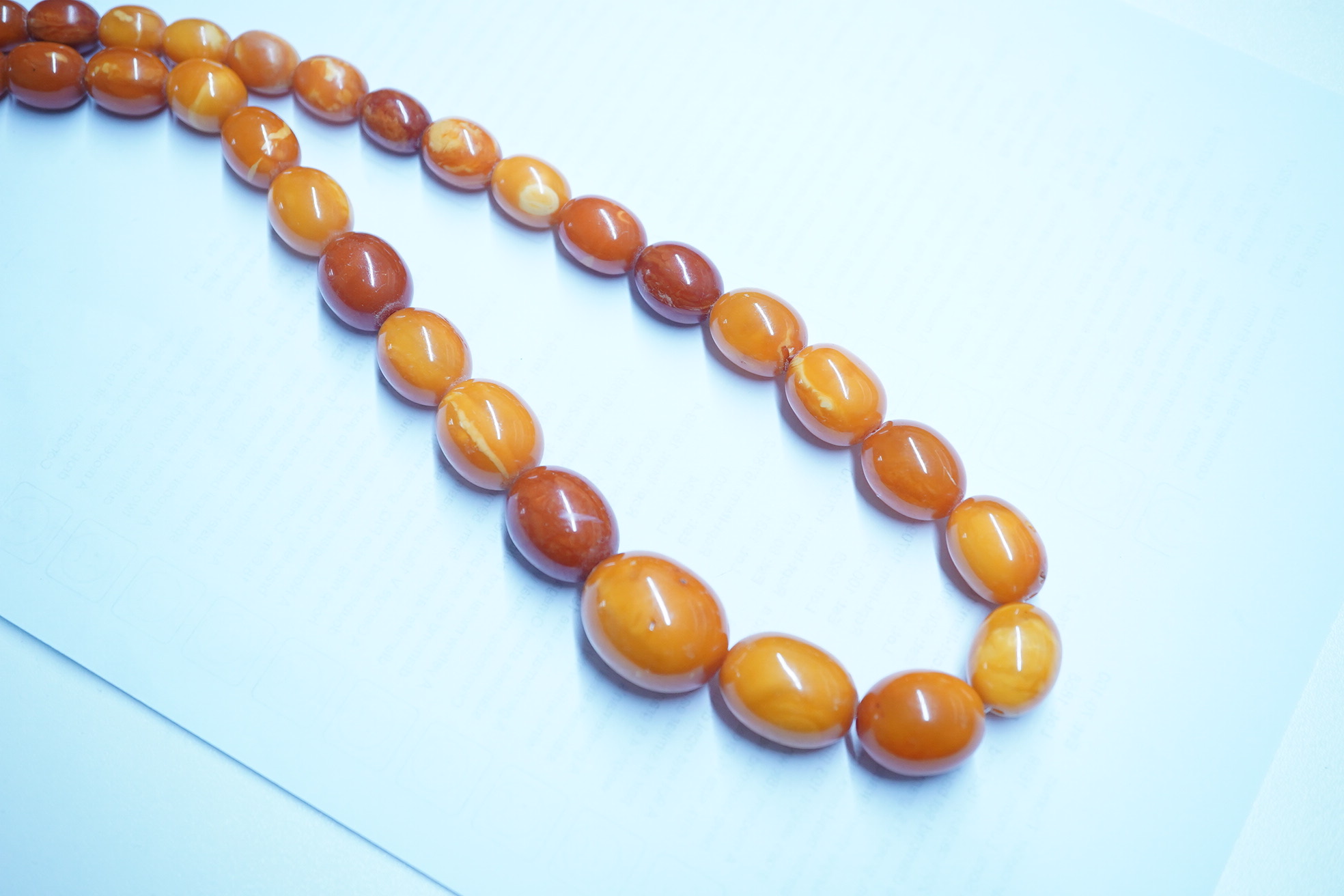 A single strand graduated oval amber bead necklace, 110cm, gross weight 103 grams. Condition - poor to fair